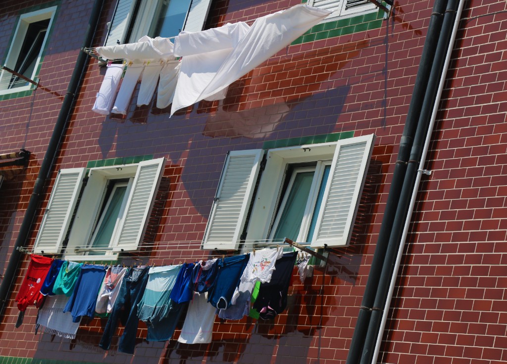Photography by Hugo Landais, laundry on lines against a tiled facade.